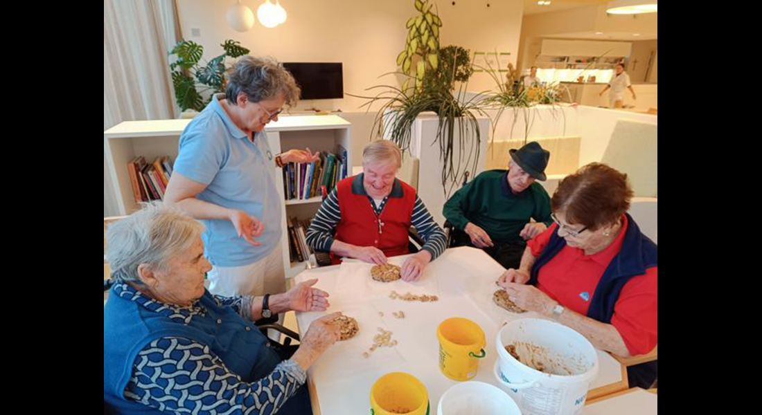 Eine Mitarbeiterin hilft den Bewohnern