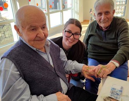 Zwei Bewohner mit bemalten Händen und eine junge Frau