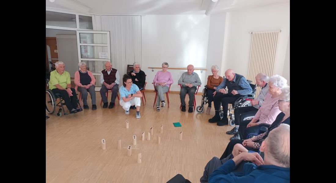 Eine Mitarbeiterin erklärt den Bewohnern das Spiel