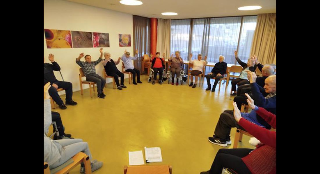 Die Teilnehmenden haben sichtlich Spaß beim Tanzen im Sitzen