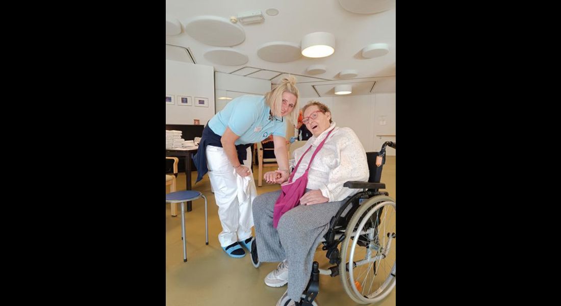 Eine Mitarbeiterin hilft einer Bewohnerin dabei ihre frisch manikürten Hände herzuzeigen