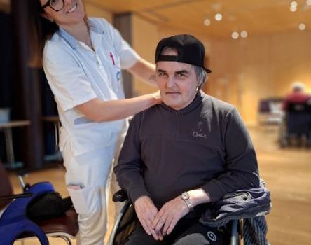 Un'infermiera e un uomo in sedia a rotelle