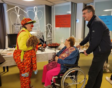 Eine Clownin im Gespräch mit zwei Personen